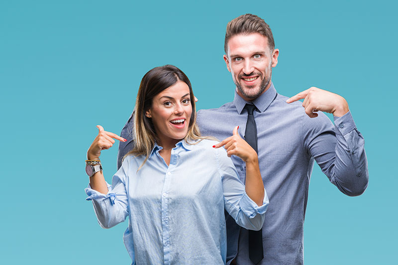 Mann und Frau in Geschäftskleidung zeigen für ihre Bewerbungshomepage auf sich selbst