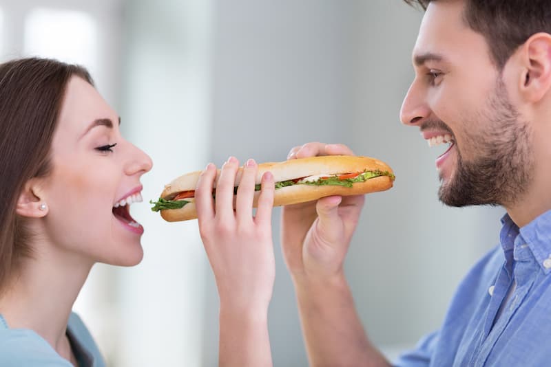 Zwei Menschen beißen in ein Sandwich, was ist die Sandwich-Methode?