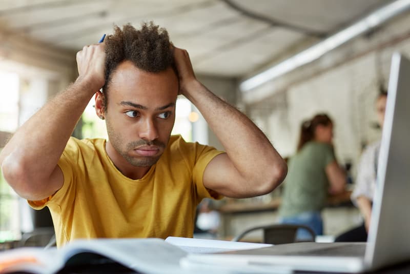 Ein Mann greift sich an den Kopf, wie entwickelt man Stressresistenz?