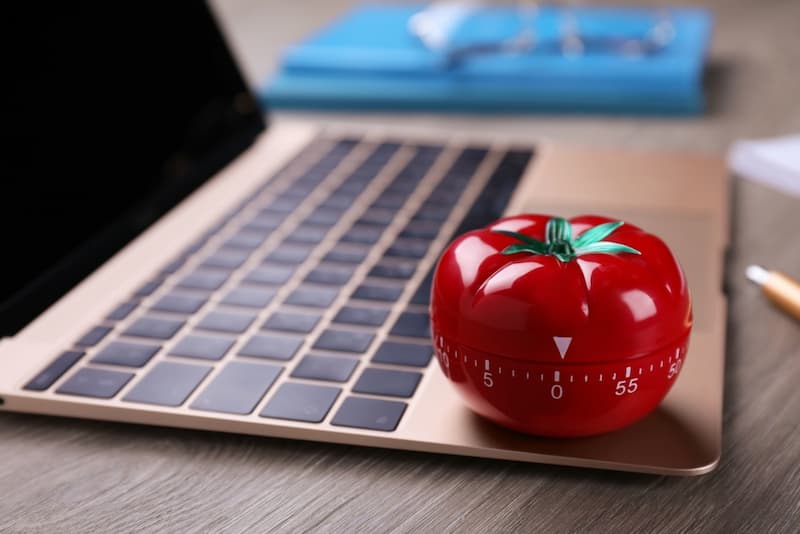 Eine Tomaten-Küchenuhr auf einem Laptop, was ist die Pomodoro-Technik?