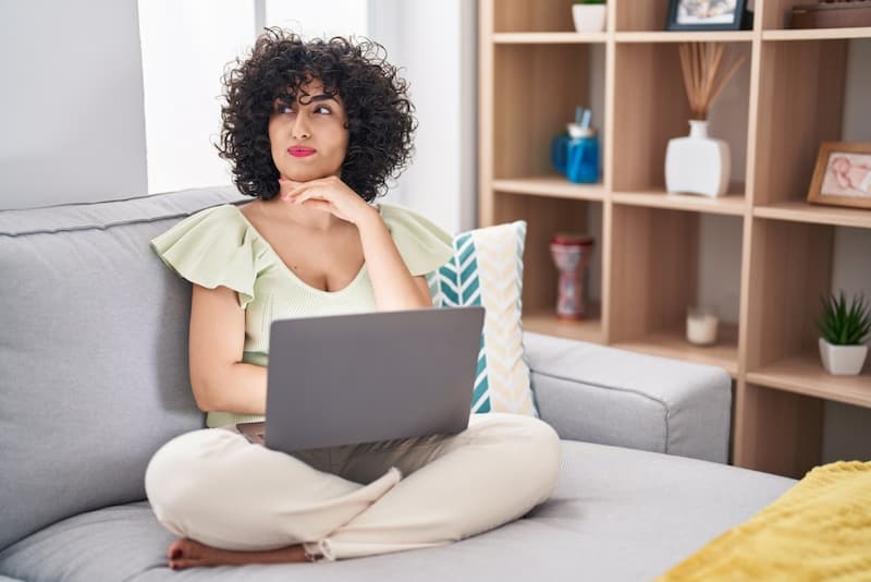 Eine Frau sitzt nachdenklich am Laptop, wie kann man Jobs ohne Berufserfahrung finden?