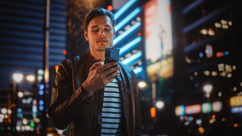 Ein Mann blickt auf sein Smartphone, was ist eine mobile Bewerbung?