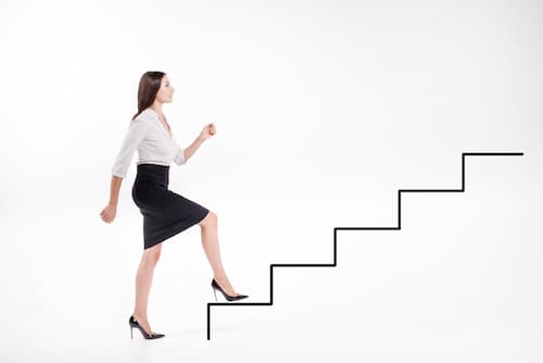 Eine Frau geht eine gezeichnete Treppe hoch, was ist Ehrgeiz?