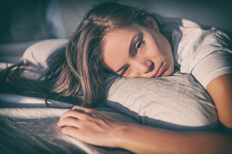 Eine Frau liegt auf einem Kissen, was ist das Chronisches Erschöpfungssyndrom?