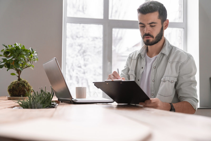 Effektive Selbstorganisation: Weniger Stress, mehr Produktivität 1 freelancer nutzt ein klemmbrett fuer seine selbstorganisation