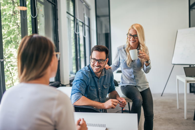 Toxic Positivity: Wenn zu viel Positivität schadet 1 Zwei Mitarbeitende zeigen Toxic Positivity und laecheln anstatt ein Problem anzusprechen