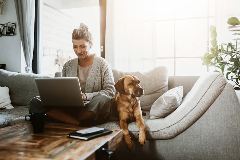 Flexibel und effizient: Alles über die Vorteile des hybriden Arbeitens 1 Frau arbeitet dem sofa und zeigt wie hybrides arbeiten funktionieren kann